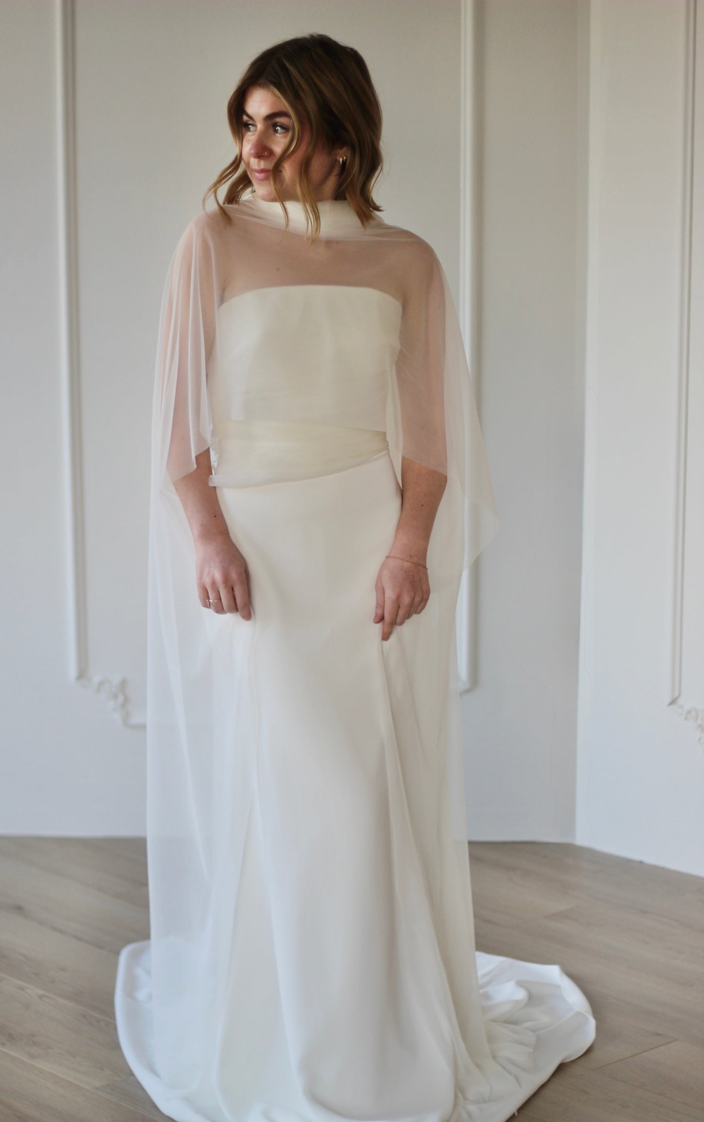 Bride wearing sheer wedding shawl over modern wedding dress