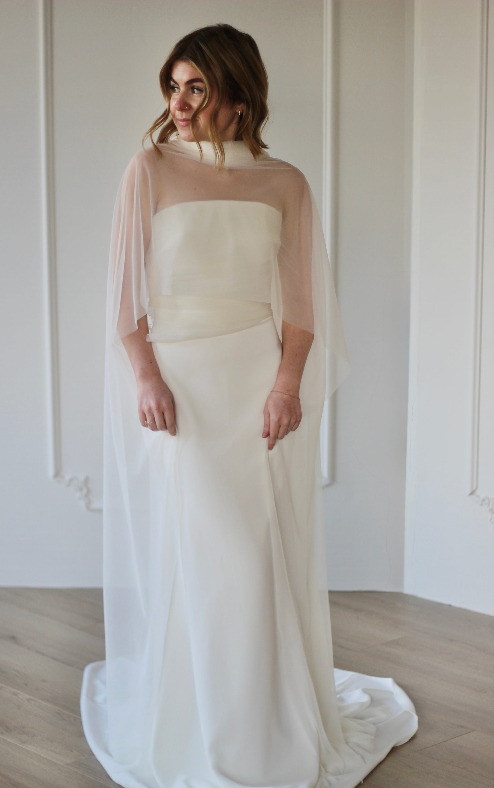 Bride wearing sheer wedding shawl over modern wedding dress