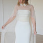 Sheer bridal capelet overlay paired over a strapless wedding dress