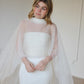Woman wearing a white wedding dress with a sheer bridal shawl