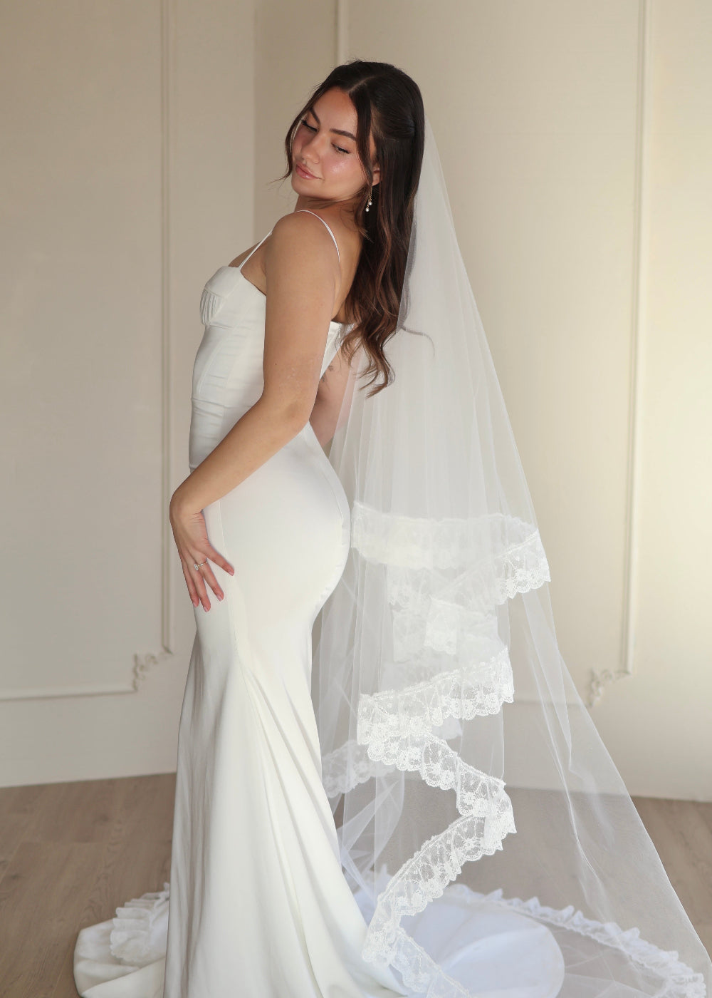 Woman wearing a wedding dress with a long lace ruffle veil